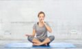 woman making yoga meditation in lotus pose on mat