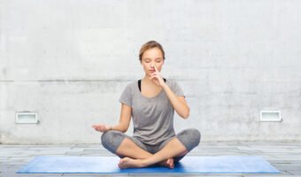woman making yoga meditation in lotus pose on mat