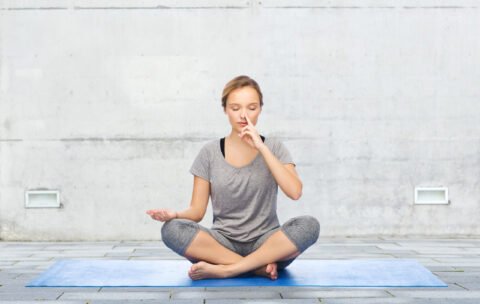 woman making yoga meditation in lotus pose on mat