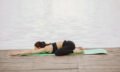 Woman practicing advanced yoga by the water